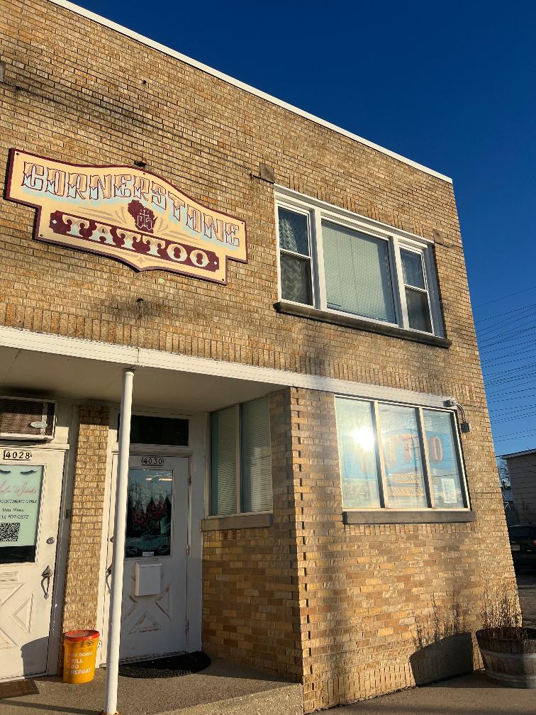 an exterior shot of a brick building that houses Cornerstone Tattoo shop